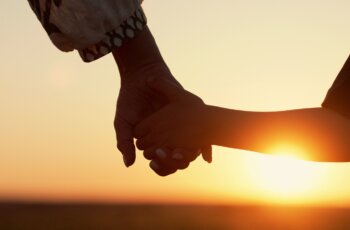 Mom,And,Child,Holding,Hands,Together,On,Sunset,Background.,Silhouette